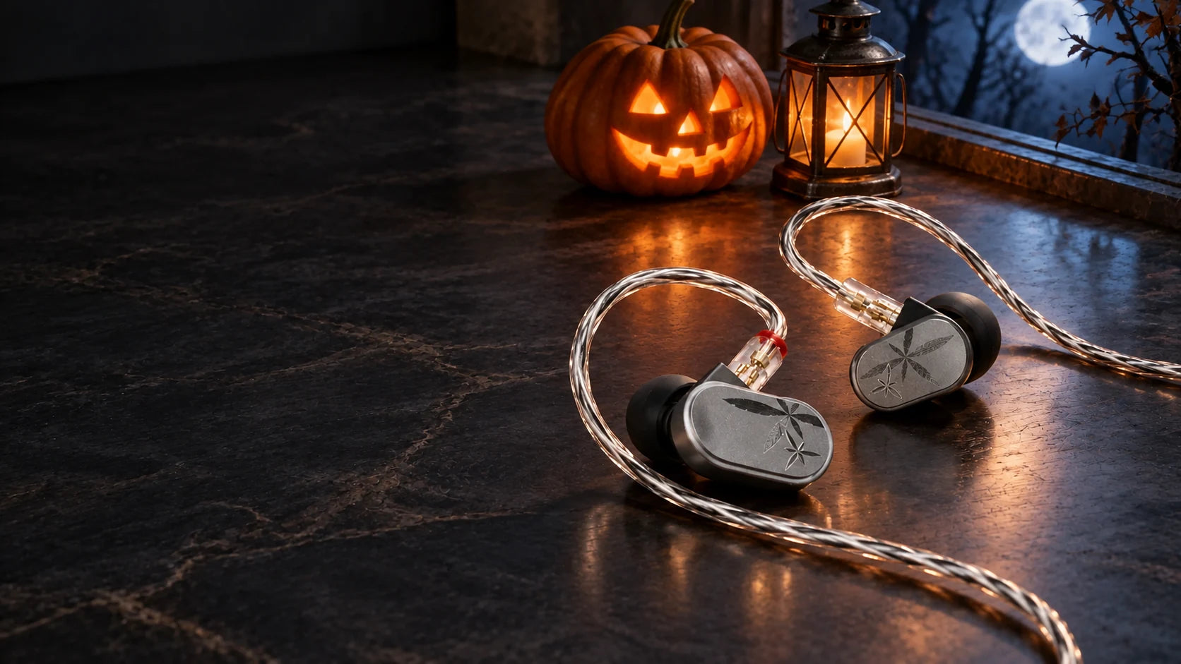 Silver MOONDROP LAN II wired earphones on a charcoal stone stage with a pumpkin and lantern beneath a moonlit window